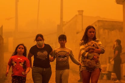 Residentes abandonan la localidad portuguesa de Covelo, rodeada por el fuego, este martes. 