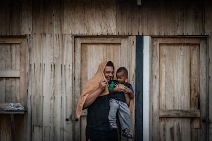 Un hombre migrante se resguardan de la lluvia con su hijo al exterior de la estación migratoria Siglo XXI de Tapachula, Chiapas