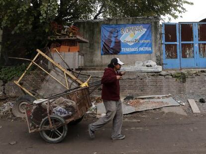 Un hombre empuja una carretilla en el barrio de La Carbonilla.