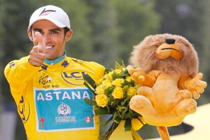Contador celebra su tercer Tour en el podio de París.