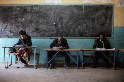 Representantes de los partidos políticos comprueban la identidad de los votantes durante las elecciones generales de Zambia.