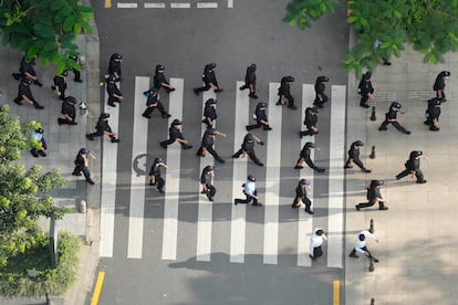 Agentes de seguridad marchan en los alrededores de la sede de Evergrande en Shenzen (China), este sábado. 