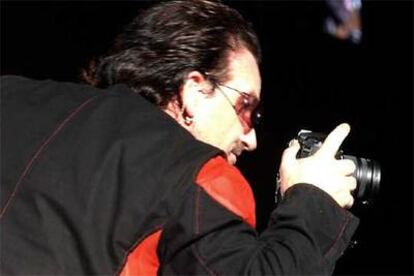 El cantante Bono, hace una fotografía del público que acudió al Camp Nou.
