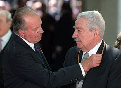 El rey Juan Carlos impone a Álvaro Mutis la medalla que le acredita como premio Cervantes.