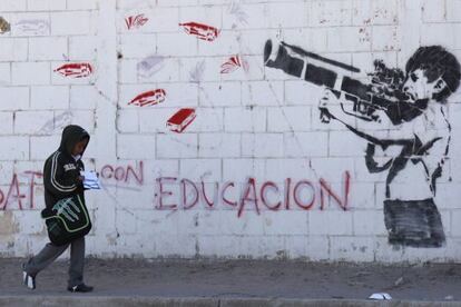 Un mural en Ciudad Ju&aacute;rez muestra a un ni&ntilde;o disparando un arma cargada con materiales escolares.