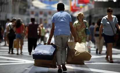 Un viandante con varias bolsas de tiendas en la calle de Preciados (Madrid). 