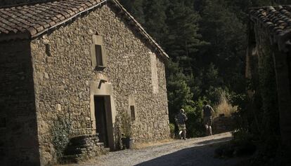 Dos niños corren ante la Masia La Roca.