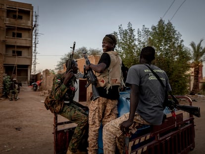 Soldados de las fuerzas armadas sudanesas conducen por el barrio de Beit Al-Mal de Jartum