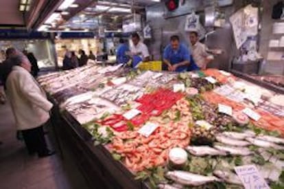 Una mujer realiza sus compras en la pescadería de un mercado madrileño. EFE