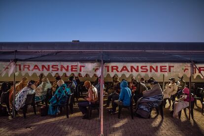 Pacientes sentados en la estación de Thaba Nchu. Muchos suelen dormir en las estaciones para estar seguros de que podrán ser atendidos la mañana siguiente.
