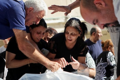 Varios cristianos lloraban el viernes ante los cadáveres de las víctimas del bombardeo israelí que dañó parte de la iglesia de San Porfirio de Gaza.