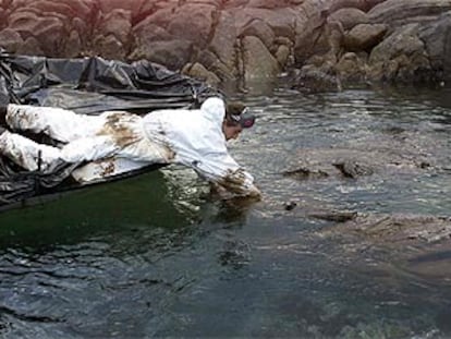 Un mariscador <b></b><i>de Santa Mariña (Camariñas, A Coruña) recoge el viscoso chapapote del Prestige</i> llegado ayer a la costa.