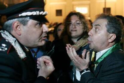 Un hombre discute a un policía italiano la decisión de cerrar el paso a la capilla ardiente.