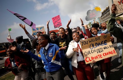 Jóvenes durante la marcha contra el cambio climático hoy en Ciudad del Cabo, Sudáfrica. En la imagen, dos niñas sujetan un cartel en el que se puede leer "Tu morirás de viejo, nuestros niños morirán por el cambio climático": 