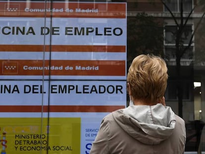 Una mujer observa un anuncio de una Oficina del Servicio Público de Empleo Estatal (SEPE).