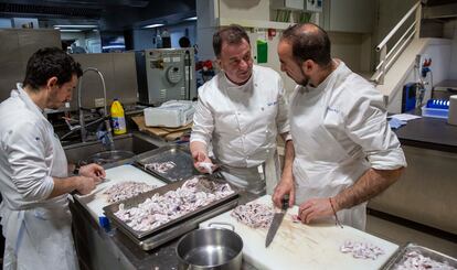 Berasategui conversa con dos cocineros de su equipo mientras manipulan unas kokotxas de bacalao.