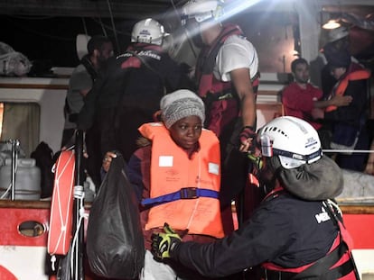 Migrantes rescatados son trasladados de un barco de una ONG a otro mayor este martes.