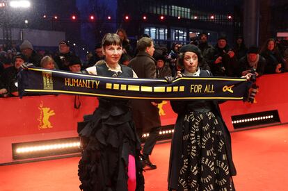 Las actrices Meret Becker (izquierda) y Anna Thalbach muestran una bufanda con el mensaje "Humanidad para todos" en la alfombra roja previa a la inauguración de la 75ª Berlinale. 