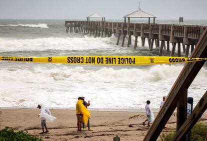 Varias personas se fotografían en la playa junto al muelle de Juno Beach, Florida, EE.UU.