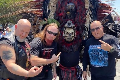 Integrantes de la banda Evil Incarnate posan con un fanático durante su gira en México.