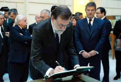 El Presidente del gobierno Mariano Rajoy, firma en el libro de condolencias en presencia del ministro de Justicia Rafael Catalá.
