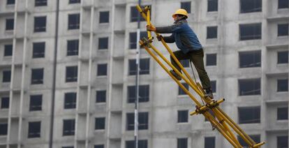 Un obrero trabaja sobre un andamio para encofrado en las obras de construcci&oacute;n de un edificio. EFE/Archivo