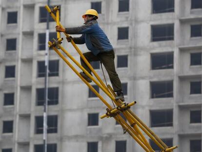 Un obrero trabaja sobre un andamio para encofrado en las obras de construcci&oacute;n de un edificio. EFE/Archivo