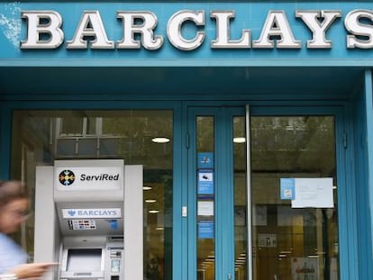 Una mujer pasa por delante de una oficina de Barclays Bank en Barcelona. 