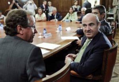 El ministro español de Economía, Luis De Guindos junto al portavoz popular en el Congreso Alfonso Alonso al comienzo de reunión mantenida esta mañana con el grupo popular en el Congreso.