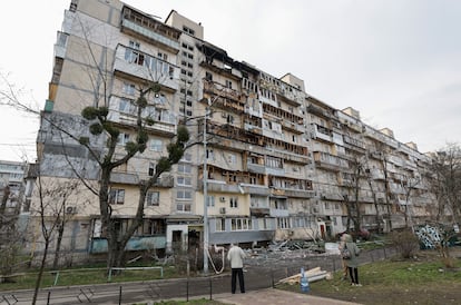 Vecinos inspeccionan los daños causados en un bloque de viviendas tras un ataque ruso en Kiev, este domingo.  