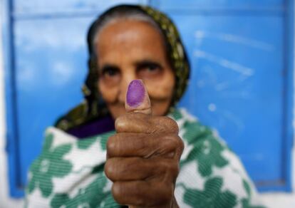 Uma mulher mostra seu dedo manchado com tinta de carimbo depois de votar durante as eleições parlamentares em Daca, Bangladesh, em 5 de janeiro 2014.