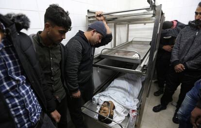 Un grupo de gente observa el cuerpo de un palestino muerto por disparos, en una morgue hospitalaria al sur de la Franja de Gaza.