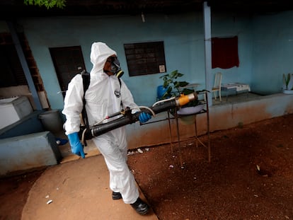 Un empleado público fumiga unas viviendas a las afueras de Brasilia.