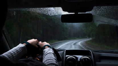 Una persona conduciendo en situación de lluvia con el cristal seco.