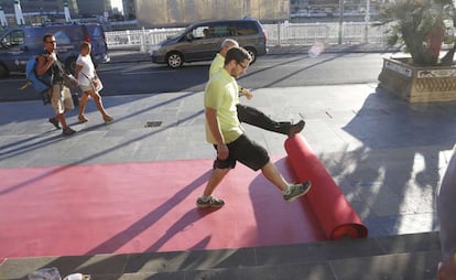 San Sebastián apura las últimas horas antes de que comience el Zinemaldia, en la imagen dos operarios colocan la alfombra roja del Teatro Victoria Eugenia.