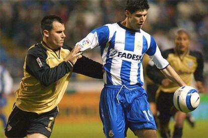 Luque, del Depor, trata de controlar el balón ante Gerardo, del Málaga.