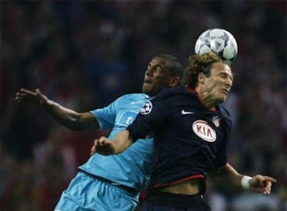 Fernando, a la izquierda, lucha por el balón con Forlán.