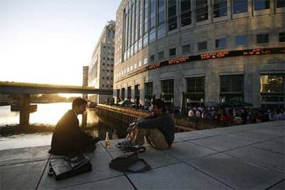 El barrio en torno a la estación de metro de Canary Wharf combina ambiente de ocio y negocio. A la derecha, el edificio de la agencia de noticias Reuters, con un rótulo luminoso de las cotizaciones en la Bolsa.