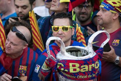 Aficionats amb una copa simulada a les mans esperen els jugadors.