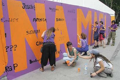 Componentes de la comparsa Mamiki escriben en su <i>txosna</i> los nombres de las mujeres víctimas de la violencia machista.