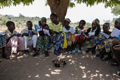 Un grupo de niños recibe lecciones a través de la radio bajo un gran árbol en el patio de la escuela en Baigaï, un pueblo cerca de la frontera nigeriana con Camerún.