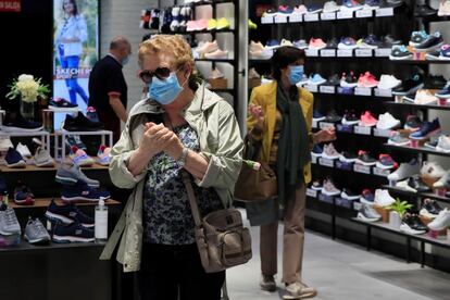 Varias personas visitan una tienda de calzados del centro comercial La Vaguada abierto desde este lunes con motivo de la activación de la fase 2 de la desescalada para toda la Comunidad de Madrid.