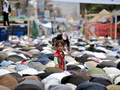 Una niña se alza entre decenas de opositores que rezan en Saná tras una manifestación contra el presidente Saleh. / yahya arhab (efe).