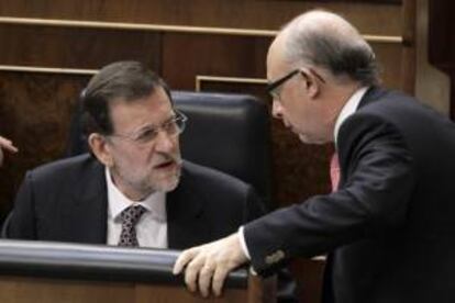 El presidente del Gobierno, Mariano Rajoy (i), conversa con el ministro de Hacienda, Cristóbal Montoro (d), durante la sesión de control al Ejecutivo, en el Congreso de los Diputados. EFE/Archivo