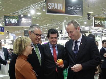 Alberto Fabra, con un caqui en la mano, en la feria Fruit Logistica de Berl&iacute;n.