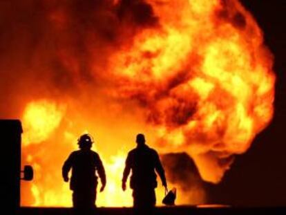 Bomberos y expertos en fugas de hidrocarburos de la paraestatal Petroleos Mexicanos (PEMEX) intentan sofocar el fuego hoy, viernes 19 octubre de 2012, tras la explosión de un gasoducto en el estado mexicano de Jalisco.