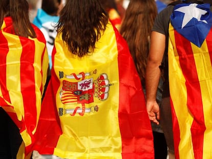 Tres j&oacute;venes acuden a una manifestaci&oacute;n en Barcelona con una estelada, una senyera y una bandera de Espa&ntilde;a.
