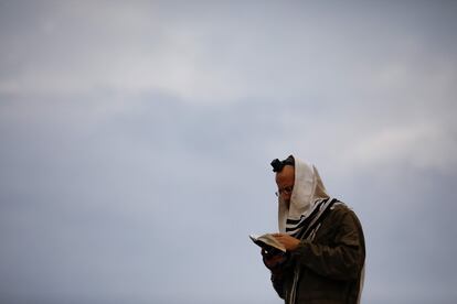 Un soldado israelí reza subido a la parte superior de un tanque situado en la zona occidental de Galilea, cerca de la frontera norte de Israel con Líbano, este lunes. 