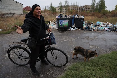 Oleksander, de "casi 70 años", con su bicicleta y una bolsa de patatas en una calle de Dobropilia.