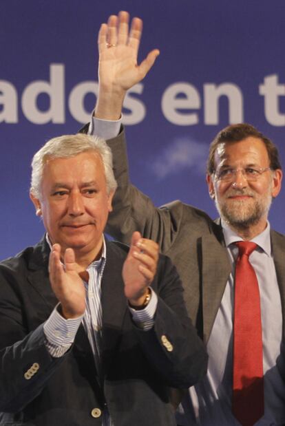 Mariano Rajoy (derecha) y Javier Arenas saludan al público en el mitin de Sevilla.